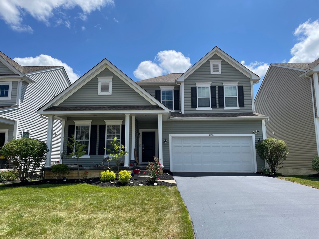 Before and after house washing on a Reynoldsburg colonial — soft-washed siding by Pinnacle Wash