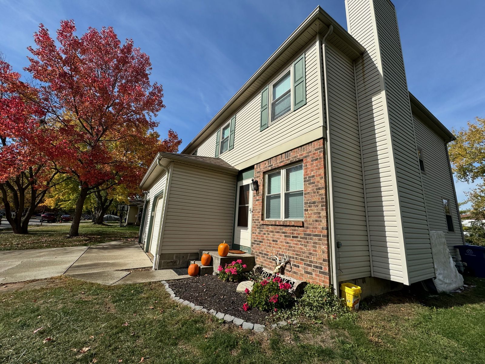 Tan two-story home freshly washed on a fall afternoon