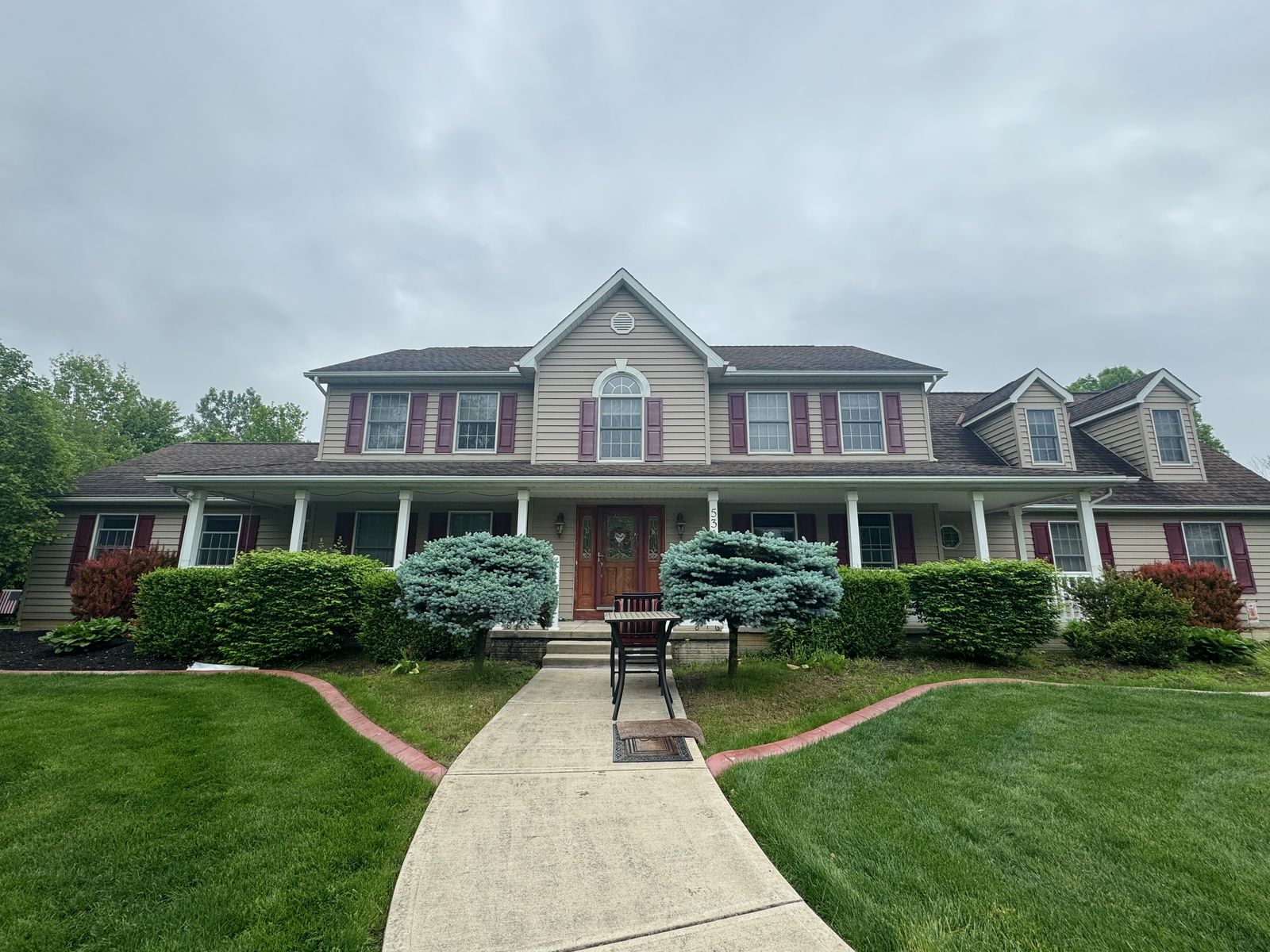 Large freshly washed colonial home with landscaped walkway — house washing by Pinnacle Wash