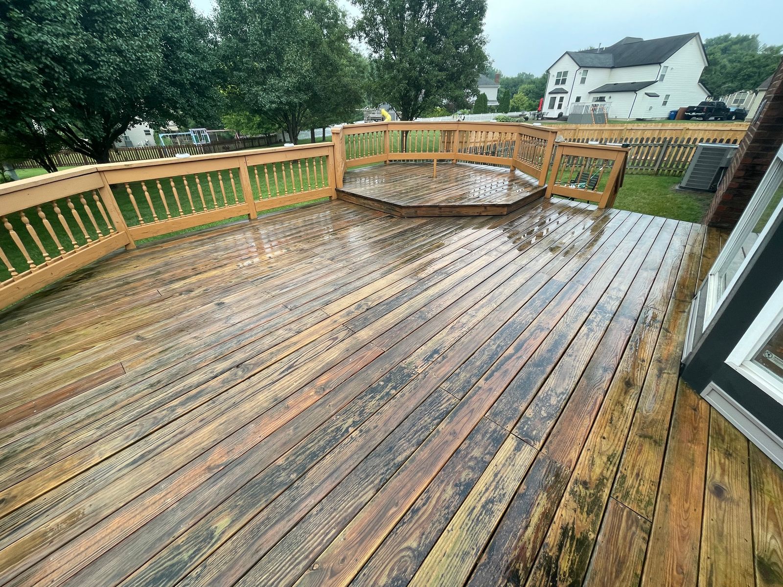 Wood deck mid-restoration, half stripped and half weathered